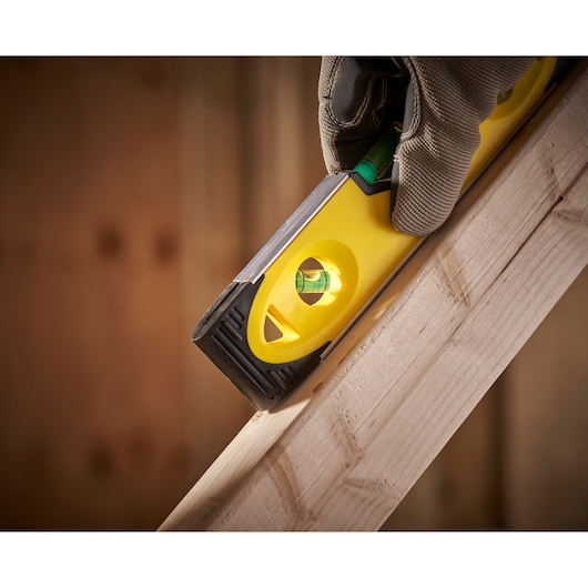 STANLEY 0-43-511 spirit level held against wood, close-up photography of tool in use.
