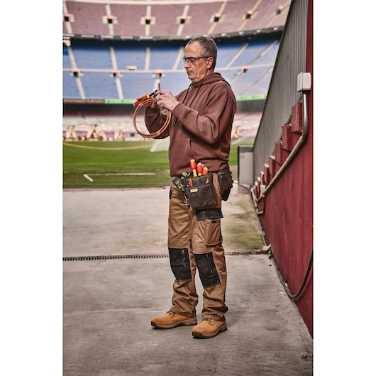 STANLEY 0-84-004 tool pouch with insulated tools on belt, worn by worker in stadium, outdoor scene.