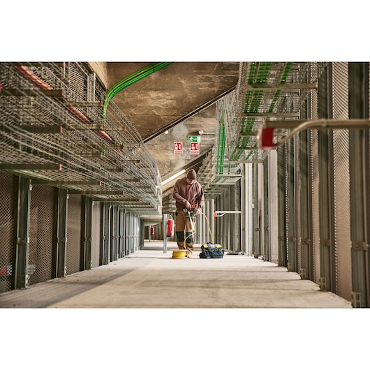 STANLEY 0-84-004 electrician working with tools in a large industrial facility, seen from a low angle.