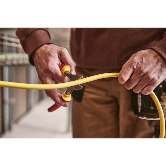 STANLEY 0-84-004 photography of pliers cutting yellow cable, close-up view.