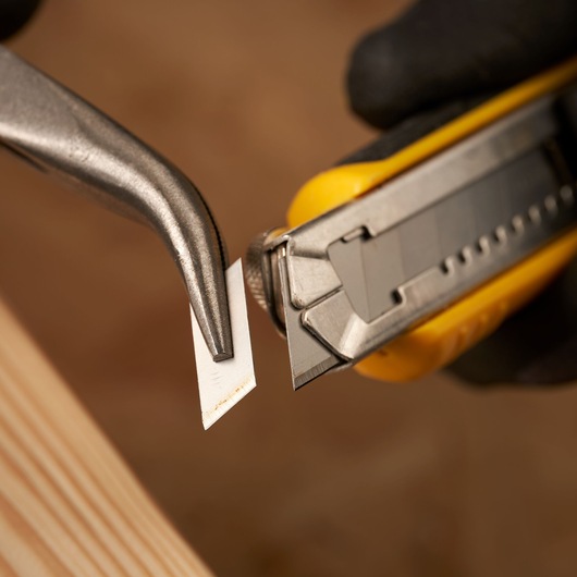 STANLEY 1-11-301 utility knife blade held by pliers, close-up photo of blade replacement.