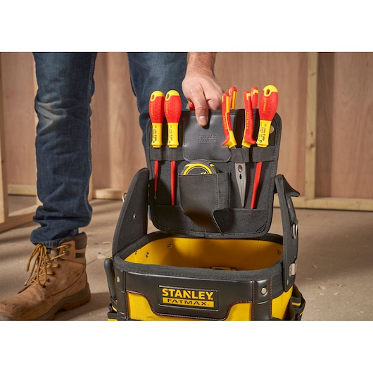 STANLEY 1-93-952 tool bag with yellow handles, open front angle, on construction site floor.