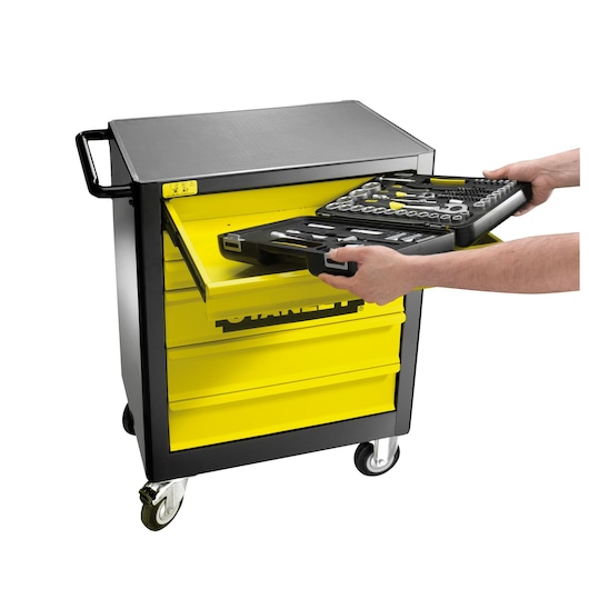 STANLEY 1-94-737 tool cabinet with open yellow drawer, person placing black tool set in drawer, side angle.