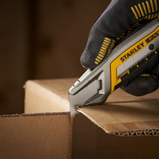 STANLEY 2-11-301 utility knife cutting cardboard, close-up photography.