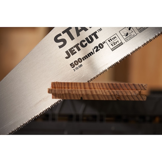 STANLEY 2-15-599 hand saw JetCut blade close-up cutting wood, photography side angle.