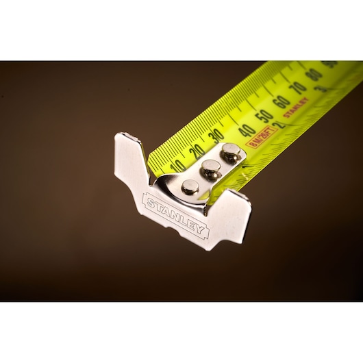 STANLEY 33-893 tape measure close-up, yellow blade with black markings and metal hook, photography.