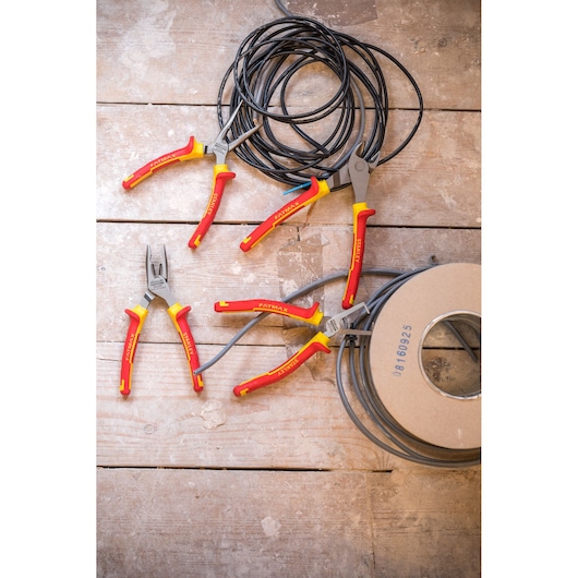 STANLEY 4-84-489 pliers set with red and yellow handles on wooden surface, shown with electrical wire, top view.