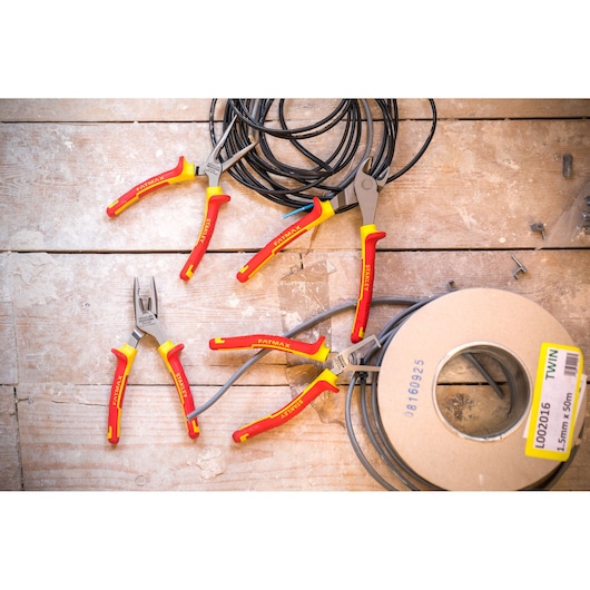 STANLEY 4-84-489 insulated pliers with red and yellow handles on a wooden surface with electrical cables.
