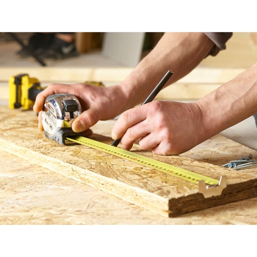 Stanley 5-33-891 tape measure in use on wood, close-up, product photography.