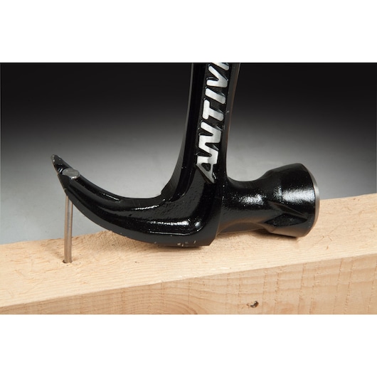 STANLEY FMHT1-51277 claw hammer side view removing nail from wood plank.