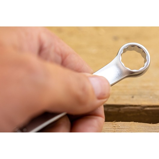 STANLEY FMMT82845-0 wrench close-up held by hand, silver finish, tool category, wood background.