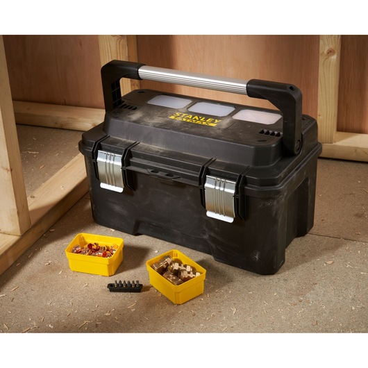 STANLEY FMST1-75792 black toolbox with metal handle, yellow removable tubs and bits, shown in workshop.