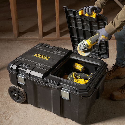 STANLEY FMST17870-1 rolling toolbox, open top view, storing power tools, on concrete floor.