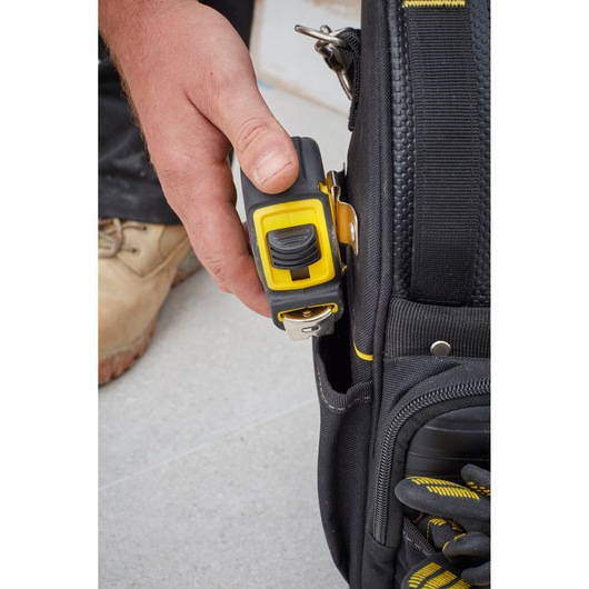 STANLEY FMST83296-1 tool bag close-up with yellow tape measure clipped to pocket.