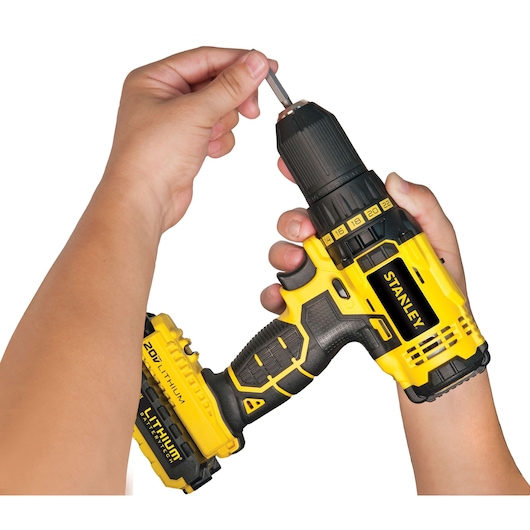 STANLEY SCD20S2K cordless drill with 20V lithium battery held in hand, close-up photography.