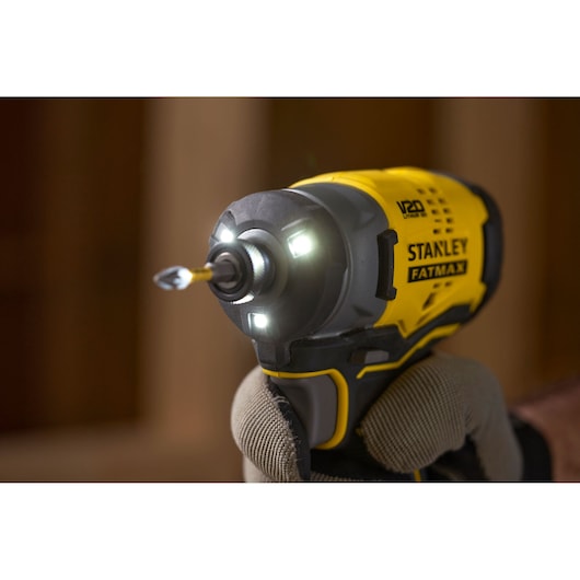 Stanley SFMCF820B impact driver with LED lights in use, close-up showing yellow and black design.