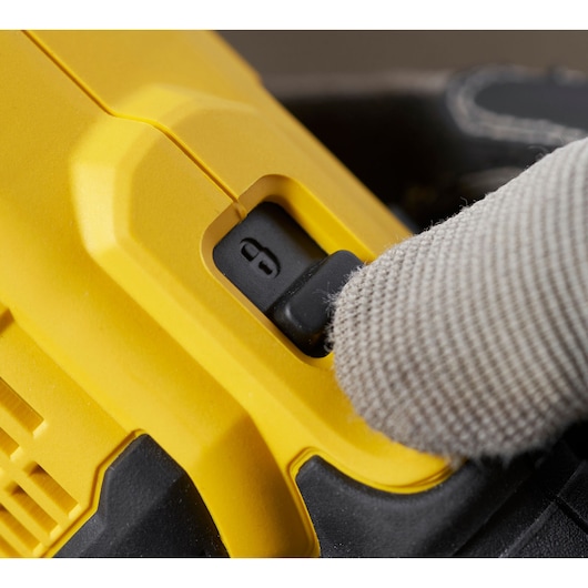 Photo of STANLEY SFMCG400D1K safety switch, close-up with gloved finger on yellow tool body.