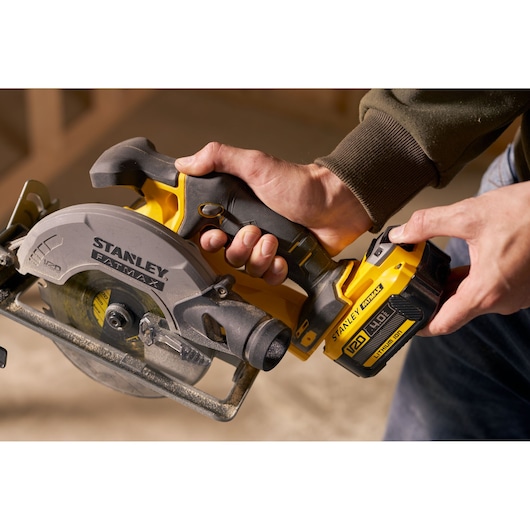 Stanley SFMCS500B cordless circular saw held in hand, close-up view of blade and battery.