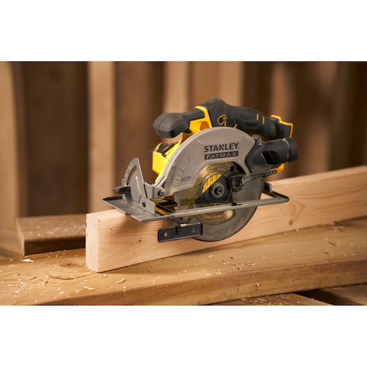 STANLEY SFMCS500D1K circular saw cutting wood plank, side view, yellow and black design.