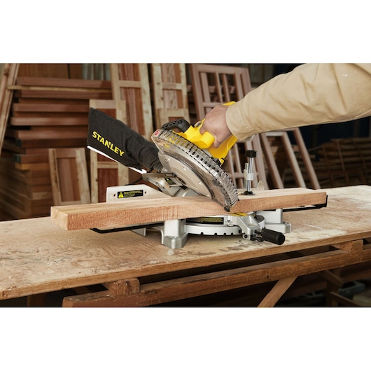 STANLEY SM16-B3 miter saw cutting wood in workshop, close-up side angle.