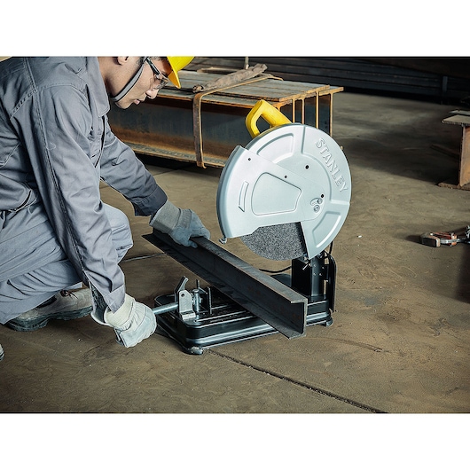 STANLEY SSC22-BR metal cut-off saw in use, worker cutting steel beam in industrial setting.