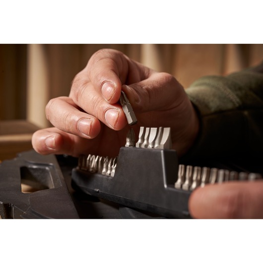 STANLEY STA7184 screwdriver bit set photography, close-up of hand selecting a silver bit from black holder.