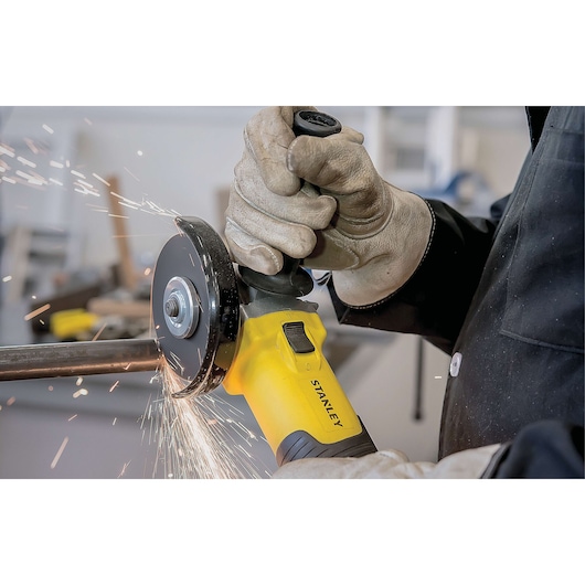 STANLEY STA8061 angle grinder in use, yellow body, generating sparks while cutting metal.