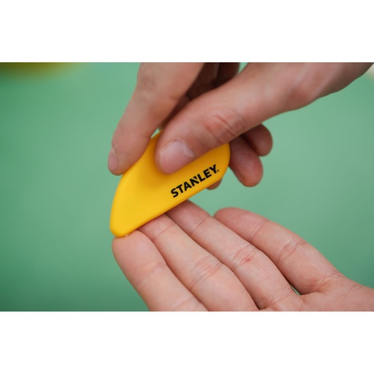 Photo of STANLEY STHT0-10291 yellow plastic tool held in hand, product close-up.