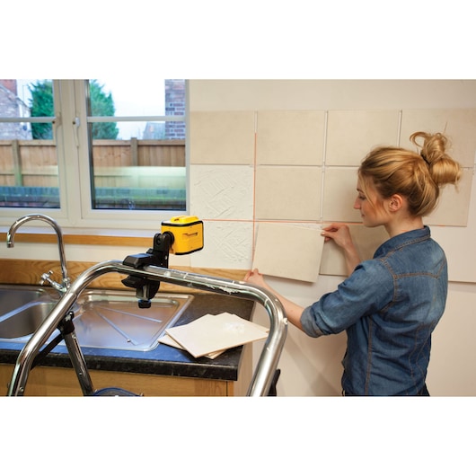 STANLEY STHT1-77340 photography of yellow laser level used for aligning wall tiles in a kitchen.