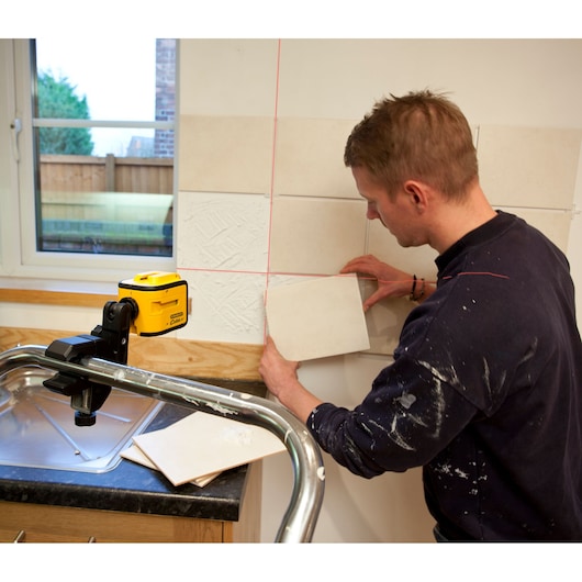 STANLEY STHT1-77340 photography of yellow laser level used for tile alignment near kitchen sink.