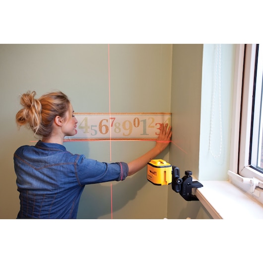 STANLEY STHT1-77340 photography of wall laser level in use, projecting lines for accurate decoration alignment.