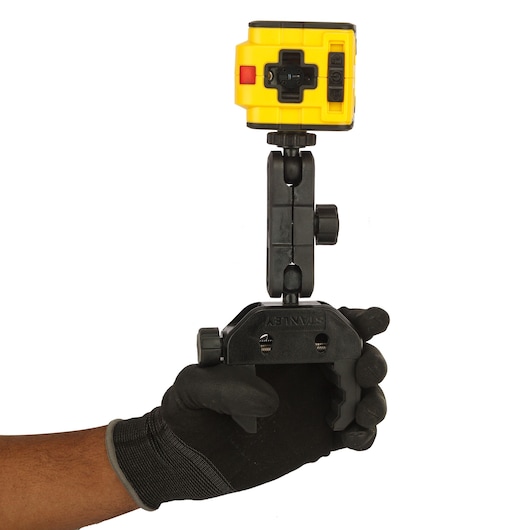 STANLEY STHT1-77340 photography clamp with yellow device held in gloved hand, front angle.