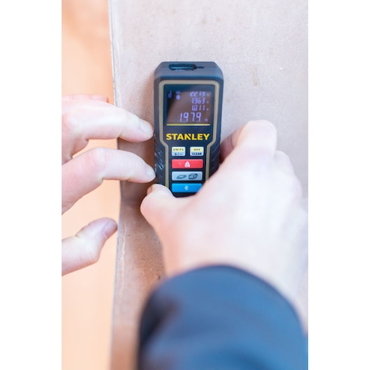 STANLEY STHT1-77361 laser distance measurer in use, close-up view, photography category.