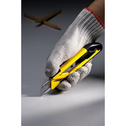 Photo of STANLEY STHT10266-8 utility knife in a gloved hand, yellow and black design, blade extended.