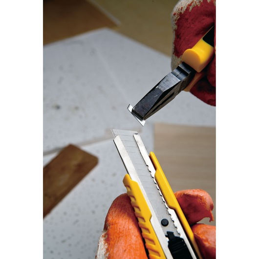 STANLEY STHT10276-8 utility knife with segmented blade, gloved hand snapping off blade section, close-up angle.