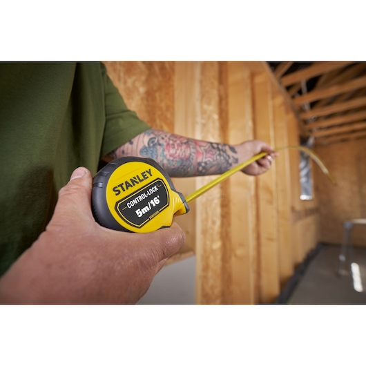 Photo of STANLEY STHT37235 tape measure, 5m/16', used in a wooden construction interior.