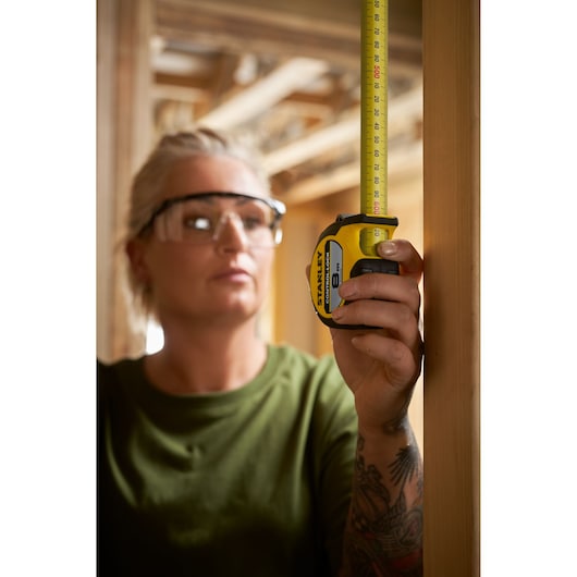 Photo of STANLEY STHT37240 tape measure held vertically during construction, yellow and black casing visible.