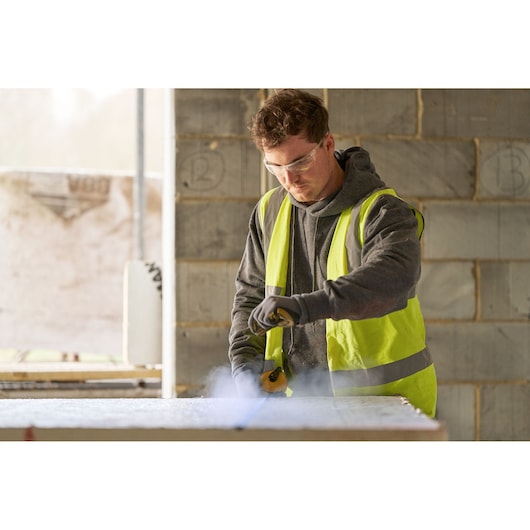 STANLEY STHT47112-0 hand tool in use on construction site, person in reflective vest holding and operating tool.