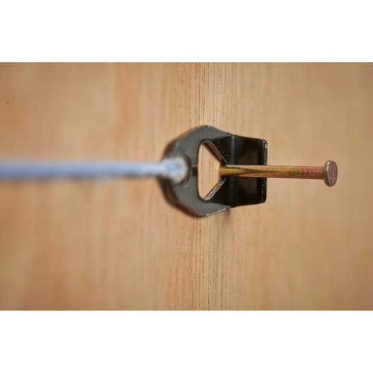 STANLEY STHT47112-0 string line holder with nail, close-up side view on wood surface.