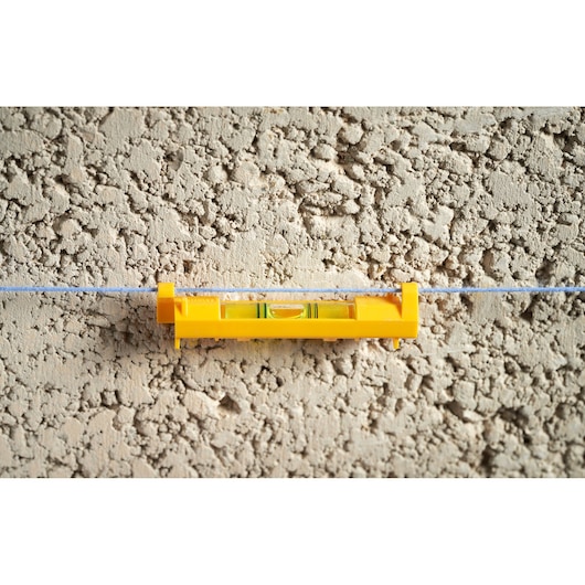 STANLEY STHT47113-0 yellow line level on masonry wall, front angle.
