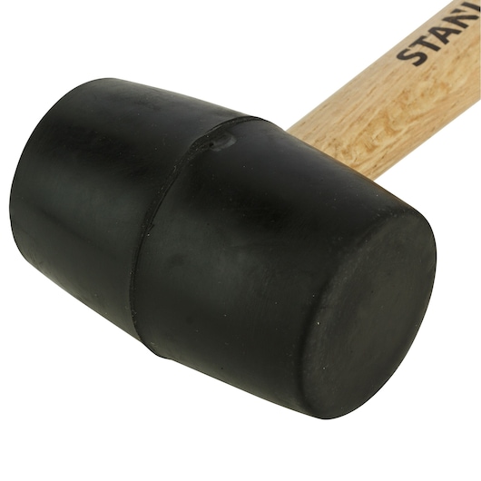 STANLEY STHT57527-8 black rubber mallet with wooden handle, close-up angle on white background.