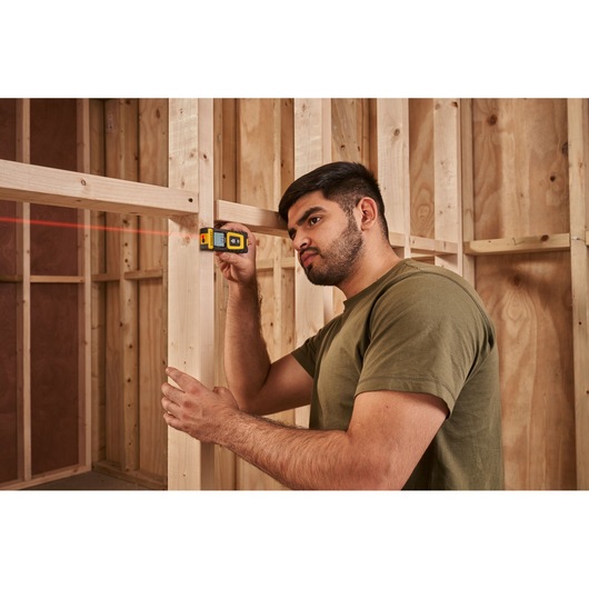 STANLEY STHT77100-0 laser level used on wooden framing in construction setting.