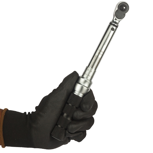 STANLEY STMT73587-8 torque wrench held in gloved hand, side angle, silver metal finish.