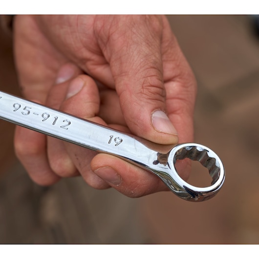 Close-up of hand holding STANLEY combination wrench with 19mm marking, from STANLEY STMT82832-1 set.