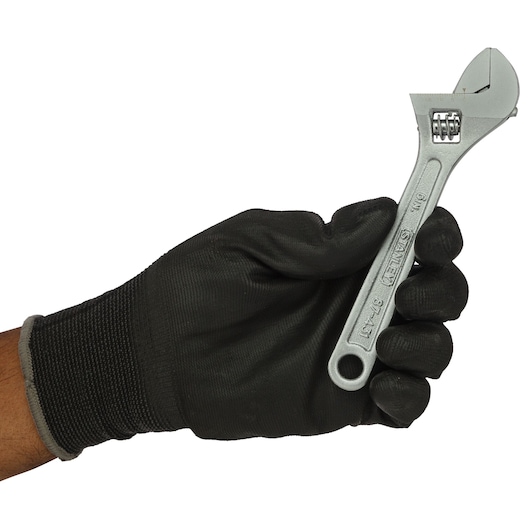 Photo of STANLEY STMT87431-8 adjustable wrench held by a black-gloved hand, side view.