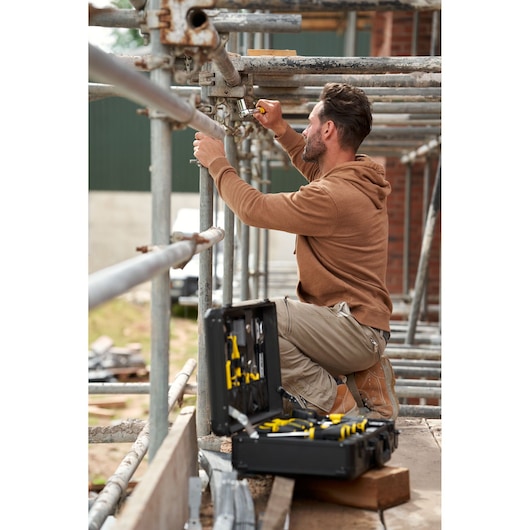 STANLEY STMT98109-1 maintenance suitcase 142PCS open on scaffolding with worker using tools outdoors.