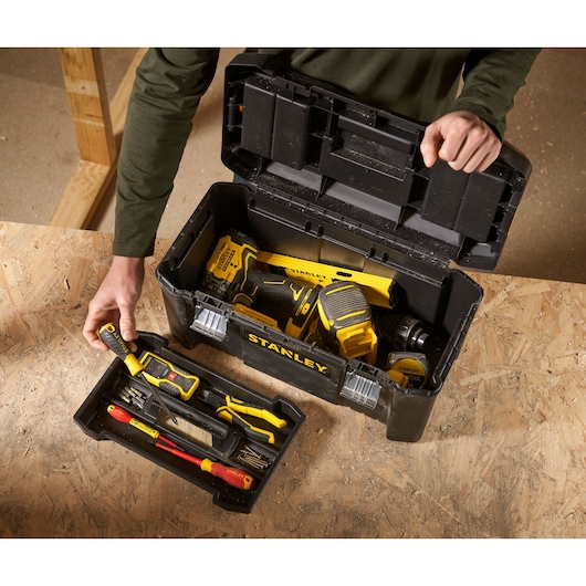 STANLEY STST1-75521 toolbox with hand tools and power tools, photographed from above on a workbench.